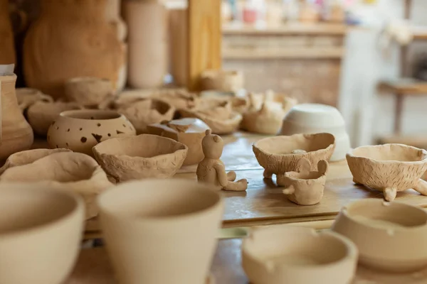 Mucchio di vasi di argilla freschi non trasformati posti su una superficie di lavoro — Foto Stock