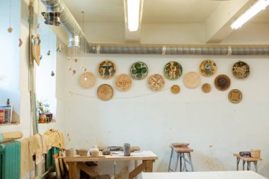 Duvarlarda dekoratif plakalar ile otantik görünümlü çömlek atölyesi