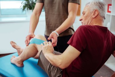 Rehabilitasyon tedavisi kursu olan güzel yaşlı adam