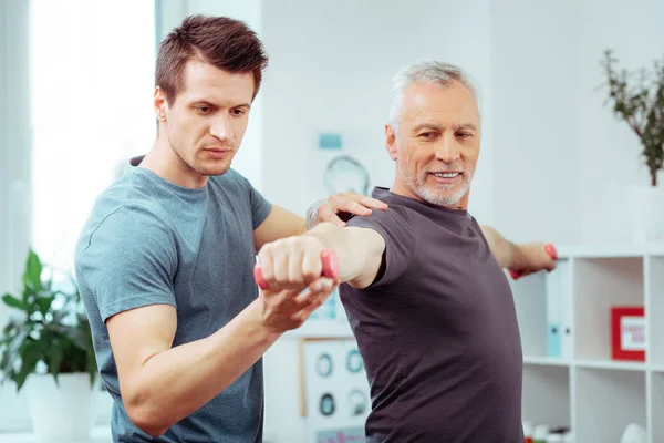 Joyful homem positivo formação com um treinador — Fotografia de Stock