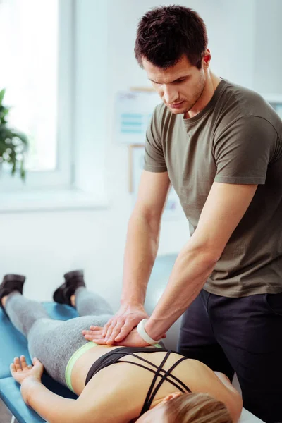 Nice professional masseur doing a back massage — Stock Photo, Image