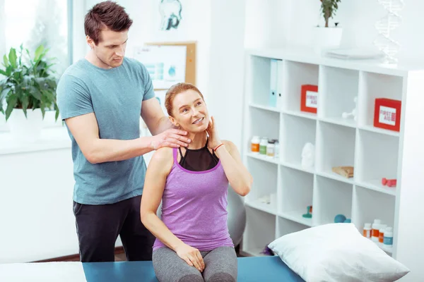 Simpatico uomo serio che fa un massaggio al collo professionale — Foto Stock