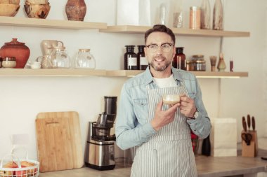 Düşünceli barista bir fincan kahve tutan.