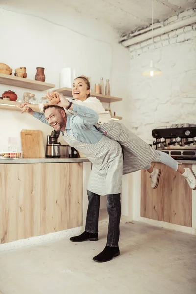 Feliz pareja jugando alrededor en su cocina . — Foto de Stock