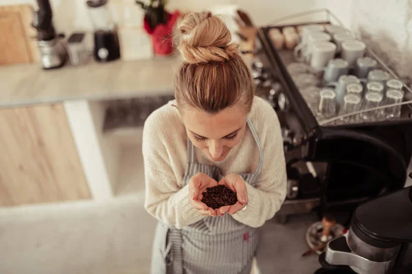 Bonito barista com um punhado de grãos de café . — Fotografia de Stock