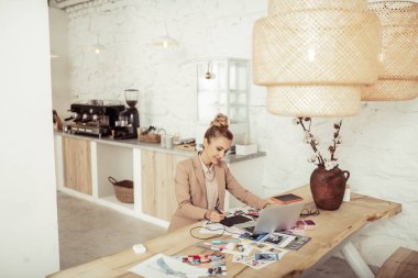Elbise tasarımları üzerinde çalışan gülümseyen bayan.