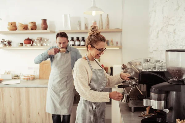Two smiling people by the coffee machine. — Stock Photo, Image