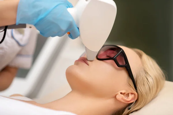 Depilatory specialist doing laser depilation above upper lip for client — Stock Photo, Image