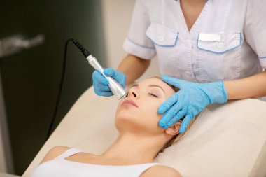 Cilt sıkılaştırma yaparken müşterinin yüzüne dokunmak dermatolog
