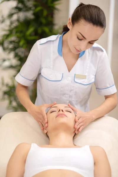 Müşteri için yüz masaj yaparken masaj ustası çalışma — Stok fotoğraf