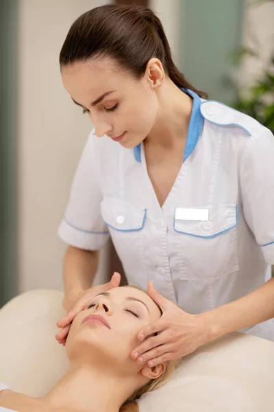 Dunkelhaarige Massagespezialisten, die Dienstleistungen für Kunden erbringen — Stockfoto