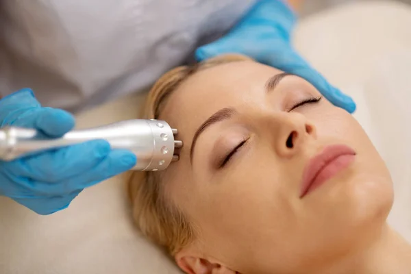 Blonde pretty businesswoman enjoying anti-aging procedures in salon — Stock Photo, Image