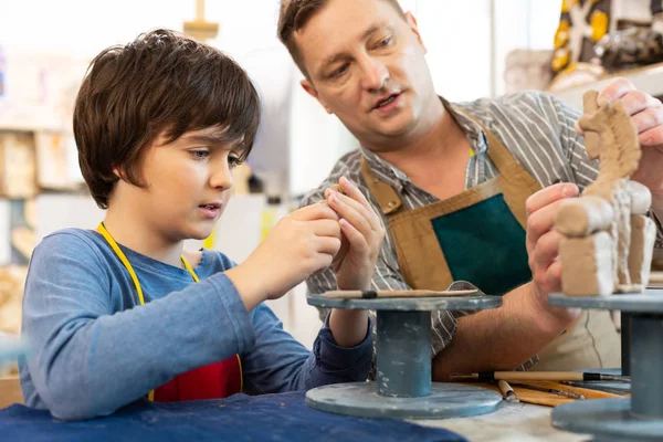 Male art teacher speaking with pupil while giving lesson about clay — Stock Photo, Image