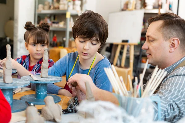 Hermano y hermana morenos escuchando a su maestro de arte — Foto de Stock