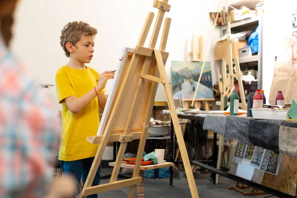 Junge mit gelbem T-Shirt auf Staffelei gemalt — Stockfoto