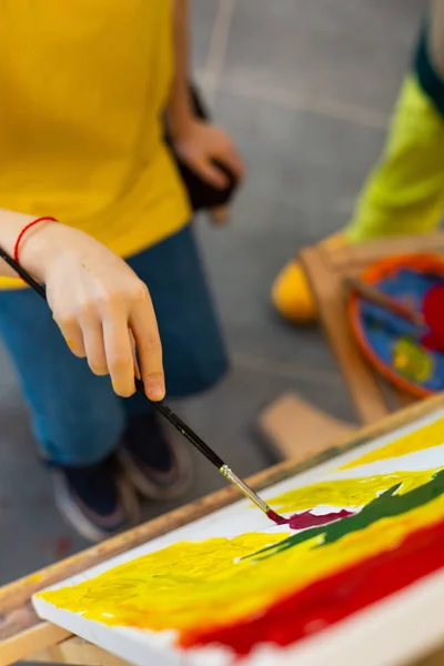 Menino segurando pincel de pintura e colorir sua imagem — Fotografia de Stock