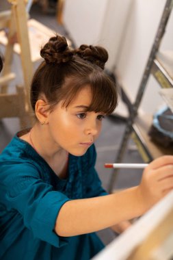 Güzel koyu saçlı kız öğrenci duygu boyama dahil