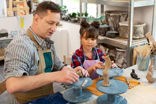 Lehrerin und süßes Mädchen modellieren kleine Tontiere in der Kunstschule — Stockfoto