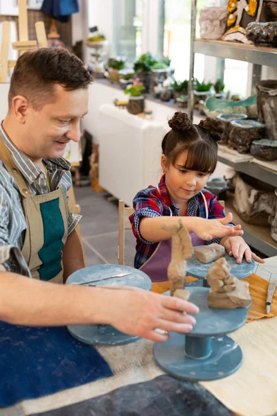 Művészeti tanár segít a kis tanuló a szobrászat agyag dolgokat — Stock Fotó