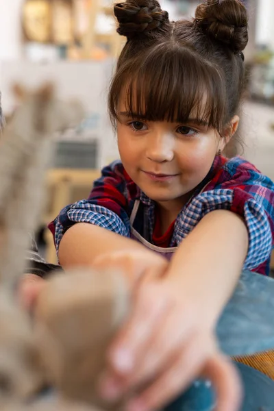 Cute dark-eyed preschool girl feeling involved n sculpting clay — Stock Photo, Image