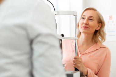 Meraklı sarışın bayan dikkatle doktorunun sonuçlarını dinlerken