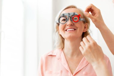 Farklı lensler üzerinde çalışırken geniş bir gülümseme ile kısa saçlı hasta
