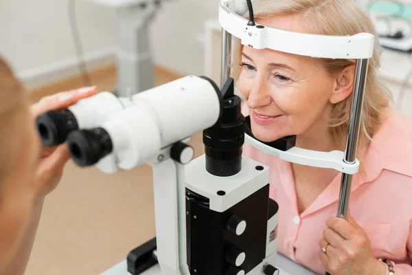 Starszy dobrze wyglądający kobieta wizyty okulisty i sprawdzanie jej wzrok — Zdjęcie stockowe