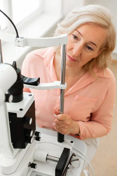 Odaklanmış kadın aparatın önünde otururken doktoruna bakıyor — Stok fotoğraf