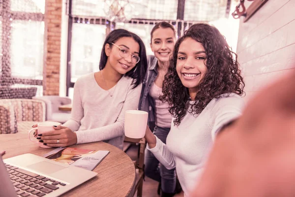 Три жінки, що посміхаються, посміхаються, роблячи фотографії, які проводять ранок у пекарні — стокове фото