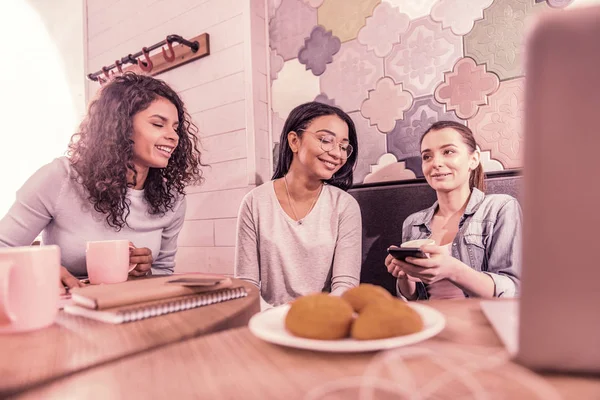 Tres madres jóvenes se reúnen en la cafetería comiendo galletas y bebiendo té — Foto de Stock
