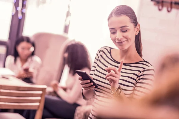 Beaming dark-haired woman having nice idea while typing message for her friend — Stock Photo, Image