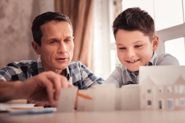 Kara gözlü öğrenci babası ile ödev yaparken gülümseyen