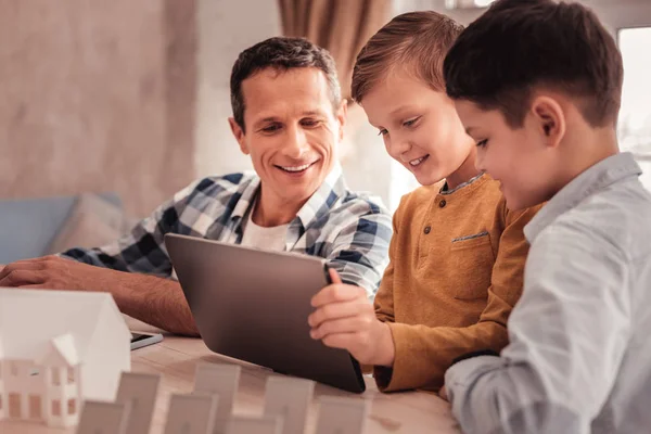 Dos lindos hijos mostrando sus fotos a padre adoptivo en la tableta — Foto de Stock