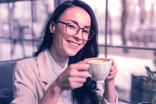 おいしいコーヒーだ彼女の飲み物を楽しみながら笑顔の喜びの肯定的な女性 — ストック写真