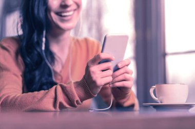 Yeni akıllı telefon. Güzel ve güzel bir kadın tarafından kullanılan yeni bir akıllı telefonun seçici odağı