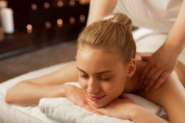 Spa merkezini ziyaret eden ve rahatlatıcı masaj alan sakin genç kadın