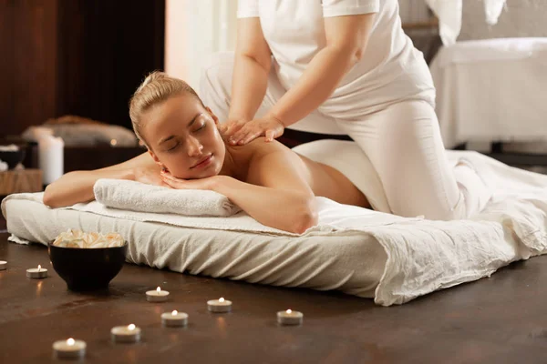 Vacker blond klient som är nöjd med erfarna massage Master — Stockfoto