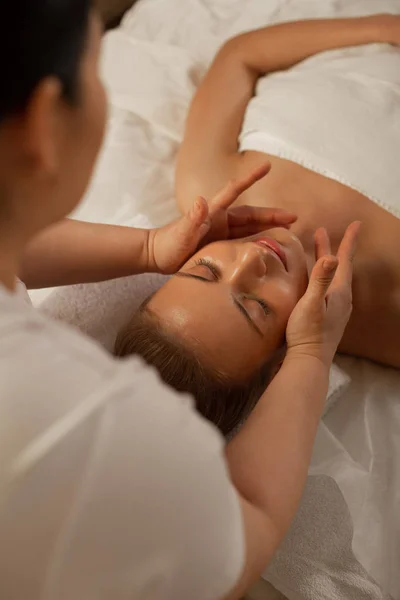 Maestro profesional que utiliza movimientos especiales durante el masaje facial — Foto de Stock