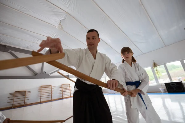 Trainerin hilft Mädchen, jo zu benutzen, während sie Kampfkunst praktiziert — Stockfoto