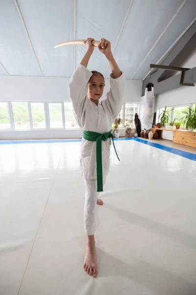 Menina amando aikido vestindo quimono branco e segurando jo — Fotografia de Stock