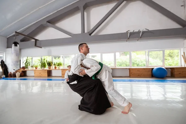 Junge im weißen Kimono praktiziert Aikido mit Trainer — Stockfoto