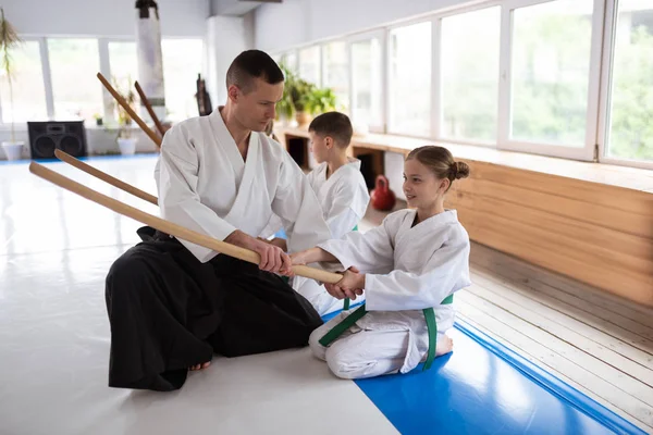 Professionelle Aikido-Trainerin arbeitet mit kleinen blonden Mädchen — Stockfoto