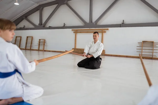 Professionelle erfahrene Aikido-Trainerin unterrichtet Kinder in der Turnhalle — Stockfoto