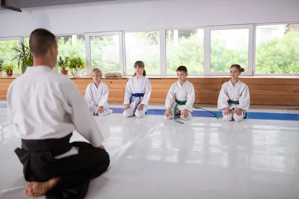 Kinder sitzen am Fenster und hören ihrem Aikido-Trainer zu — Stockfoto