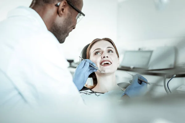 Dark-Skinned wykonawczy stomatolog przewożących swoje narzędzia z obiema rękami — Zdjęcie stockowe
