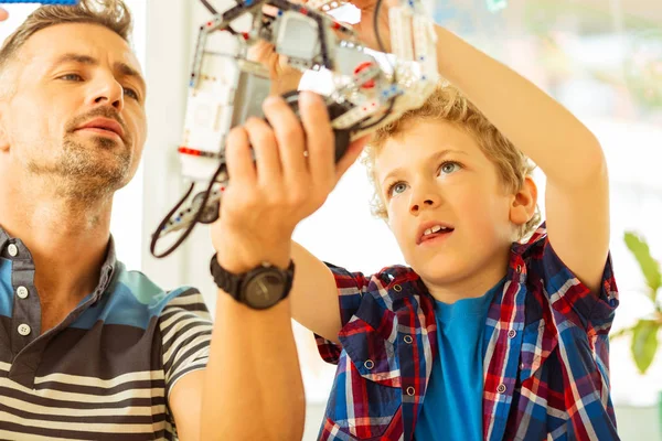 Simpatici padre e figlio piacevole costruzione di un robot insieme — Foto Stock