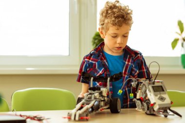 Ciddi kıvırcık çocuk araç modelleri bakıyor