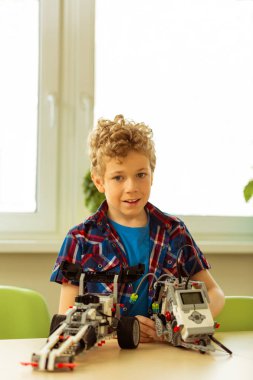 Olumlu neşeli kıvırcık çocuk size gülümseyen