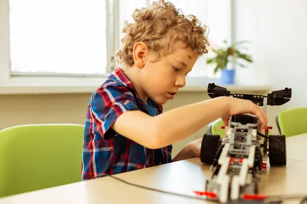 Niedlicher kleiner Junge hält ein Spielzeugfahrzeug — Stockfoto