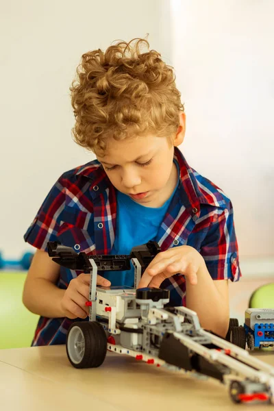 Intelligent cute nice boy constructing a car — Stock Photo, Image